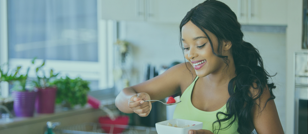 How Healthy is Your Diet? Woman eating a cup of fruit.